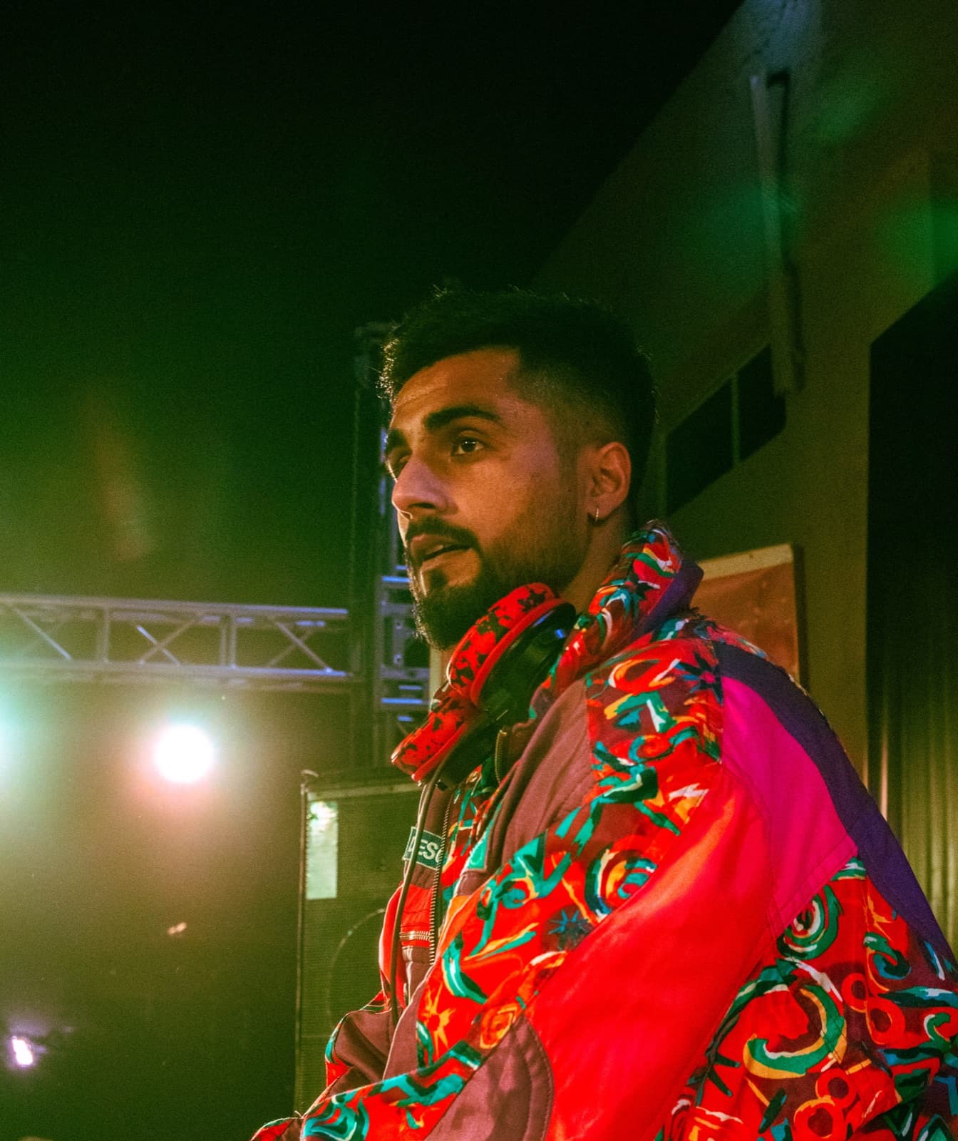 TOSHI on stage in a bold red embroidered jacket
